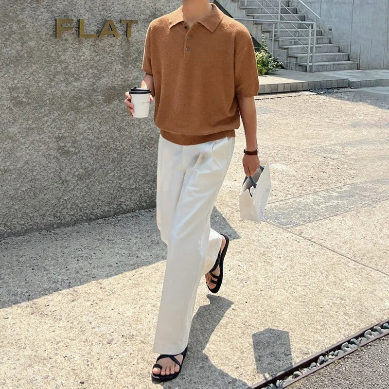 A caramel coloured men's loose-fit knitted polo shirt with short sleeves on a hanger.