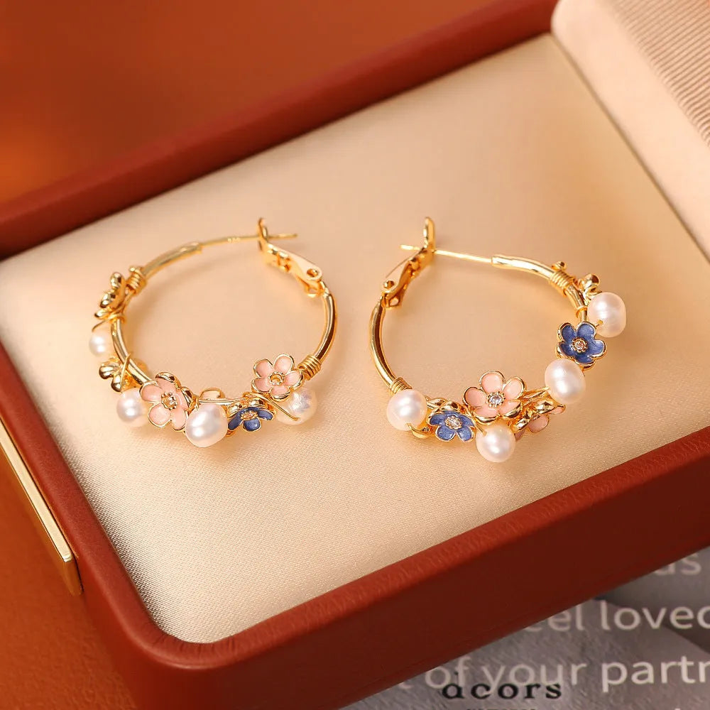 Natural freshwater pearl flower earrings with gold-plated copper setting, pair of earrings on display