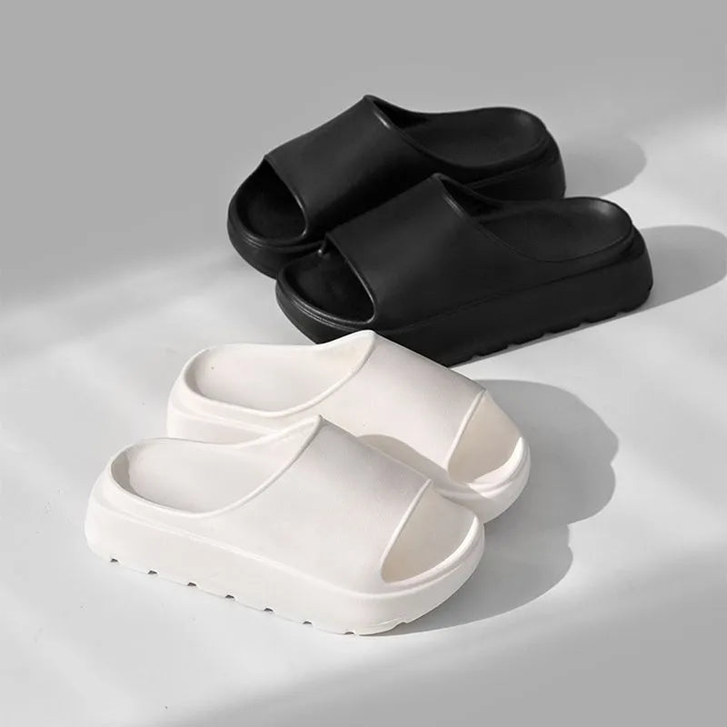 Women's beige thick-soled EVA beach slippers with fish mouth design on a wooden floor.