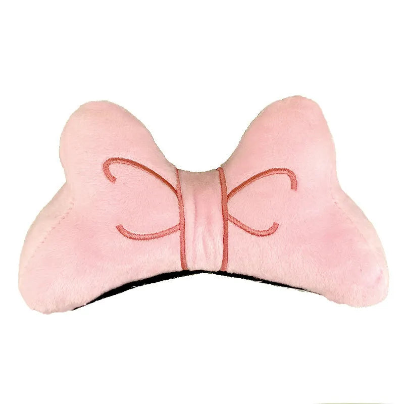 Soft red plush bow tie decoration for helmet customisation, shown against a helmet shell.