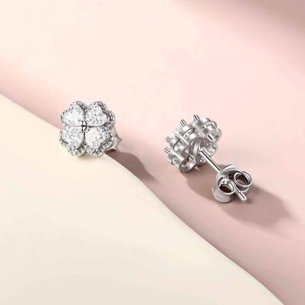 A pair of women's silver stud earrings with a four-leaf clover and heart design, white gold colour finish.