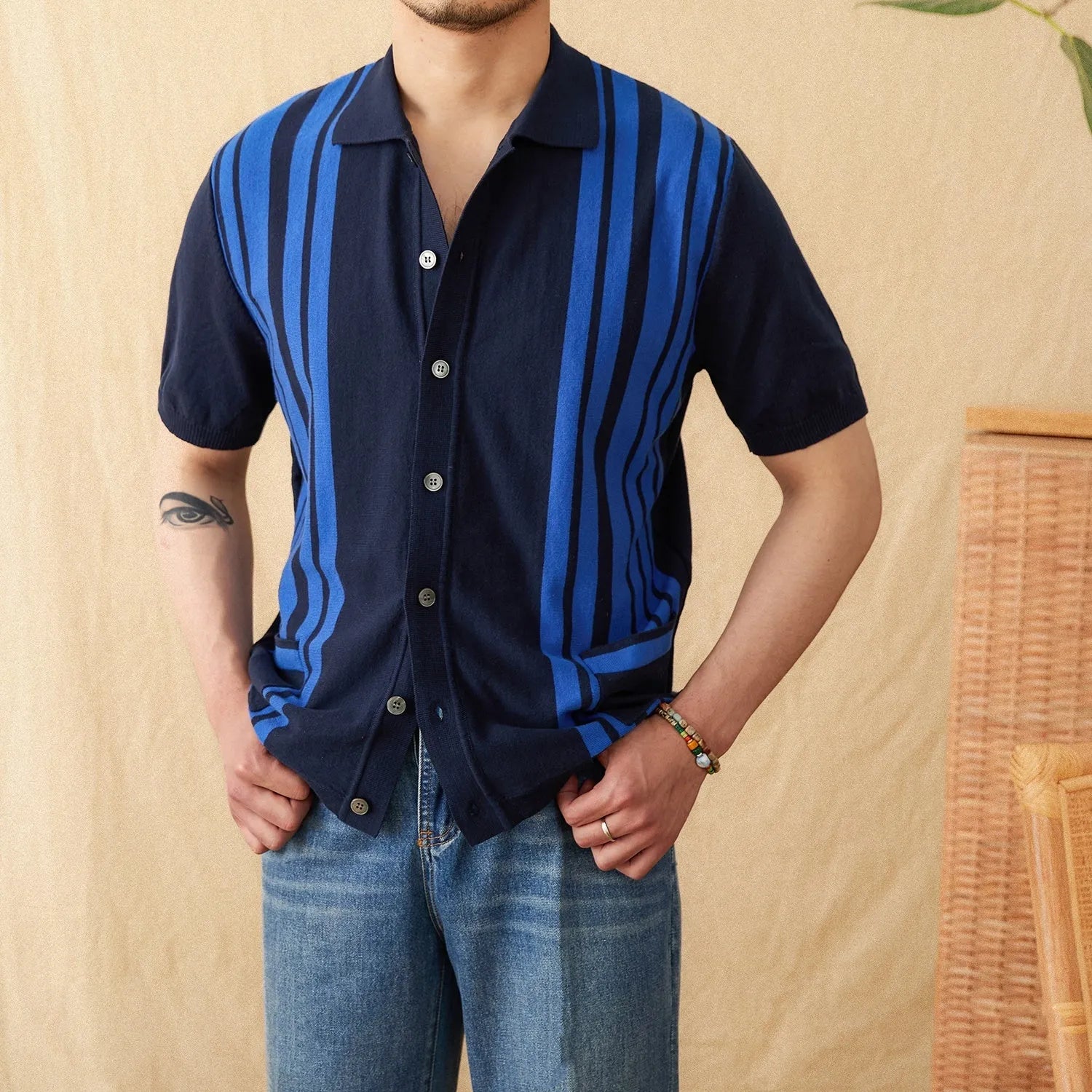 A striped knitted cardigan polo shirt with short sleeves and a lapel collar, shown in a light blue colour.