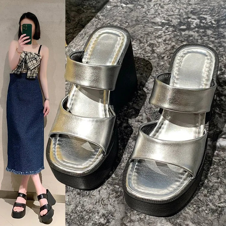 Women's black wedge platform slippers with square toe on a white background.