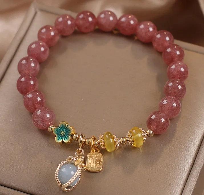 Red strawberry quartz beaded bracelet with metal alloy setting and sparkling rhinestone details.