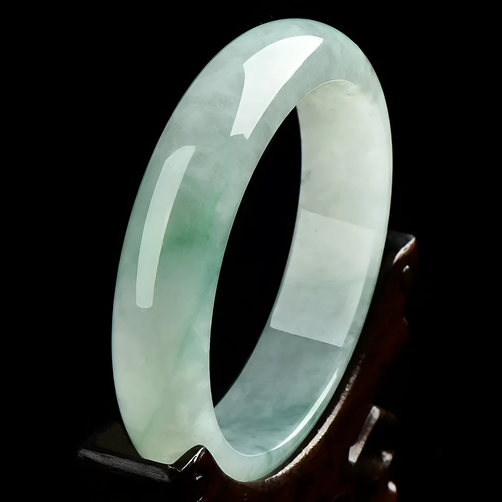 Light green jade bracelet on a wrist, showing its natural stone texture and colour.