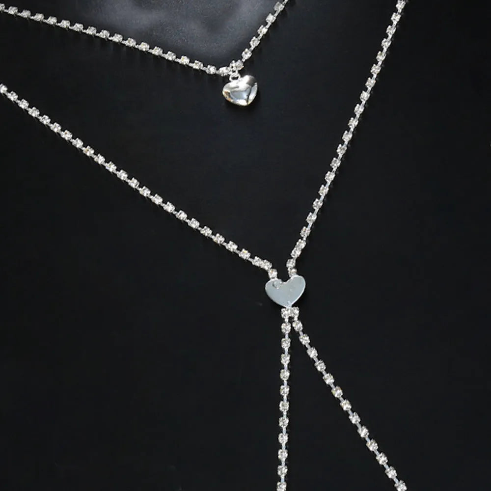 Gold or silver coloured heart-shaped body chain for women with rhinestone detailing.