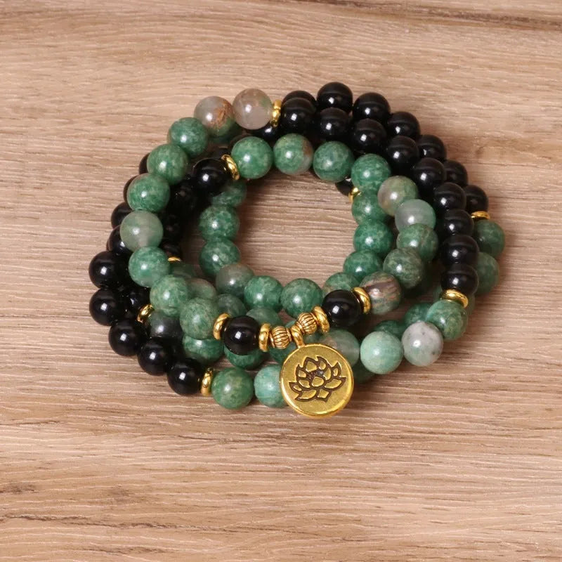 Green and black alloy beads on an elasticated bracelet, shown on a wrist.