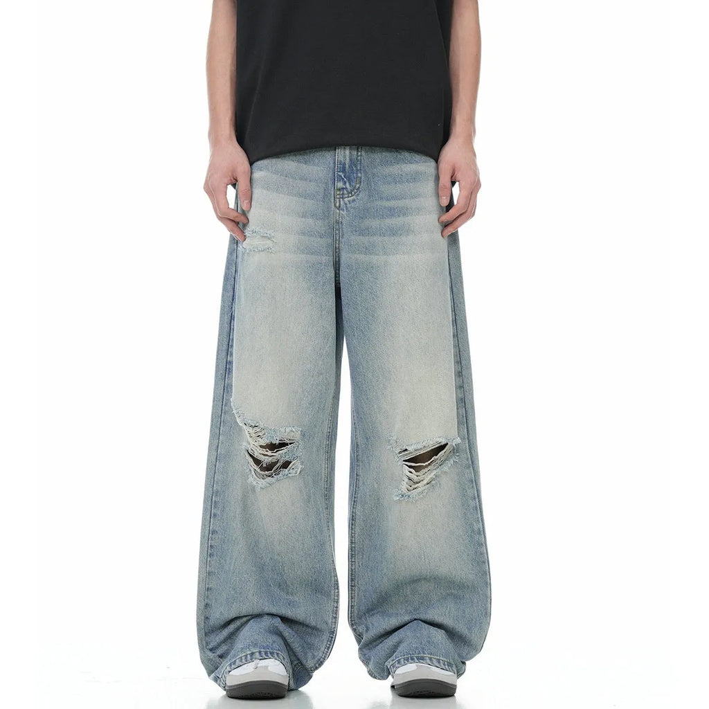 Men's blue straight-leg jeans with distressed ripped details and a zipper fly.