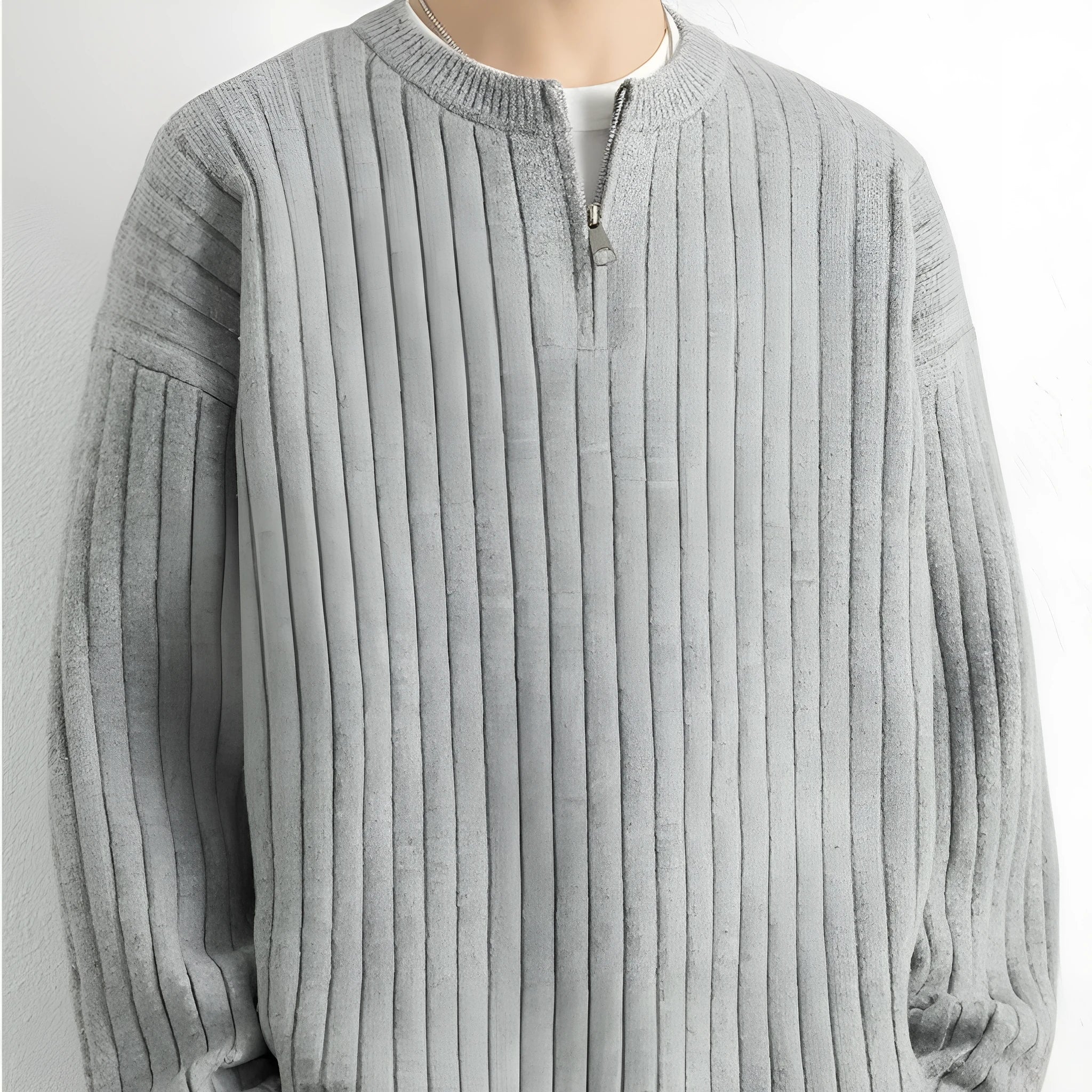 Man wearing a loose grey half-zip textured knit pullover sweater.