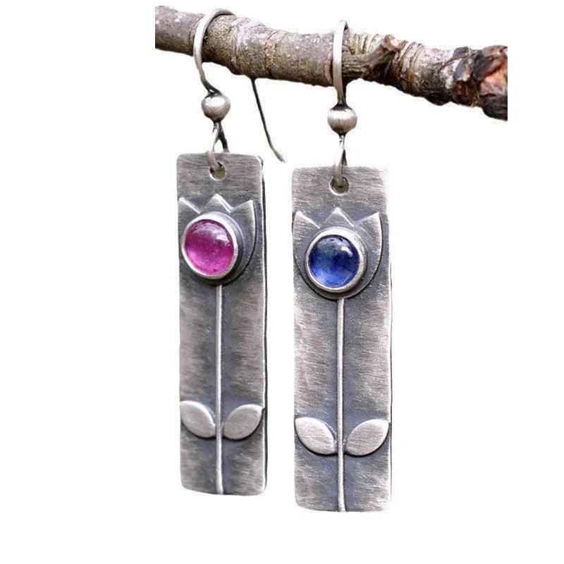 Pair of antique finish red sapphire geometric ellipse earrings with retro style on a white background.