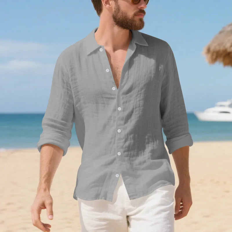 A man wearing a loose-fit light blue linen casual shirt with a non-iron finish, buttoned front and standard collar.