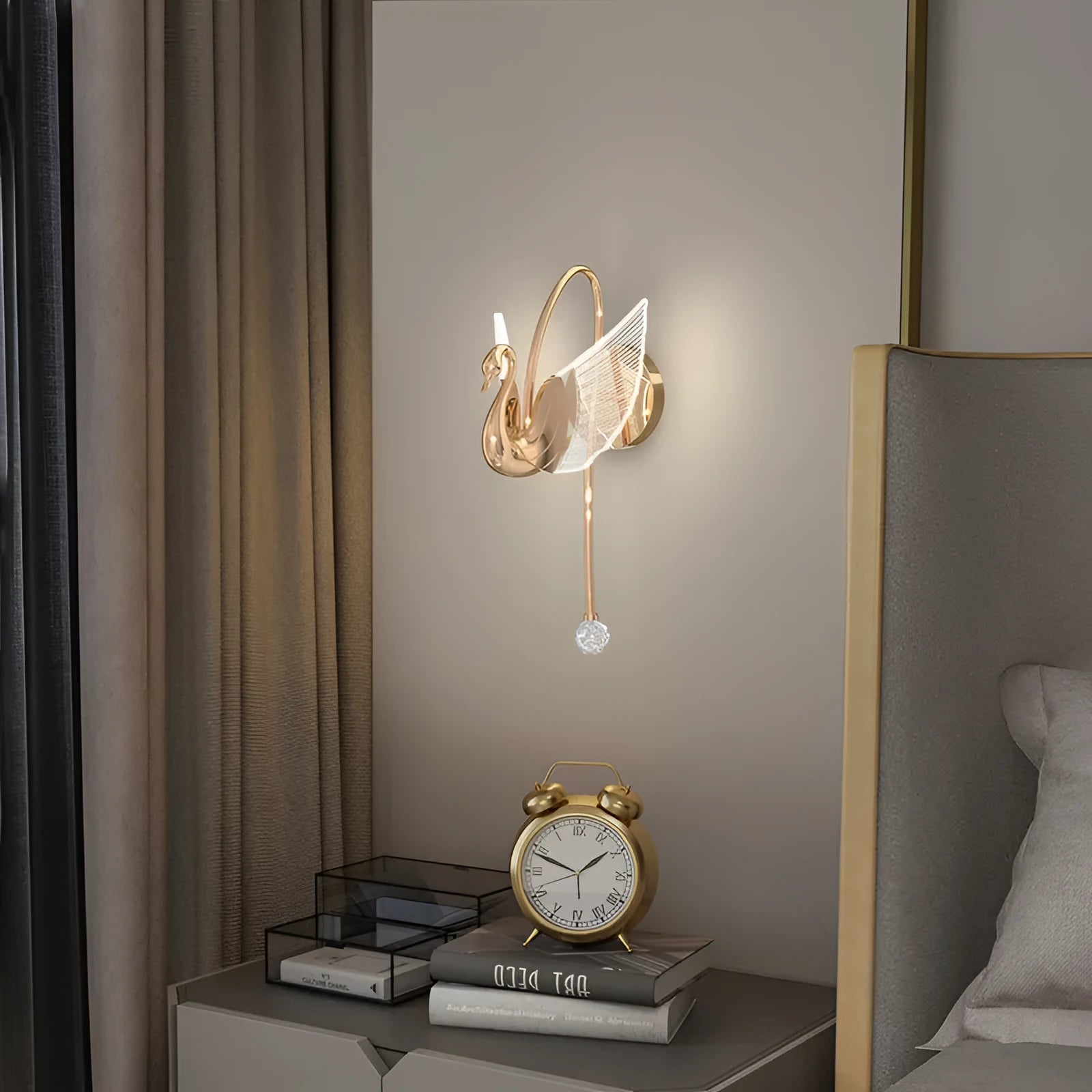 Gold modern minimalist swan-shaped LED wall lamp with an acrylic shade on a wall.