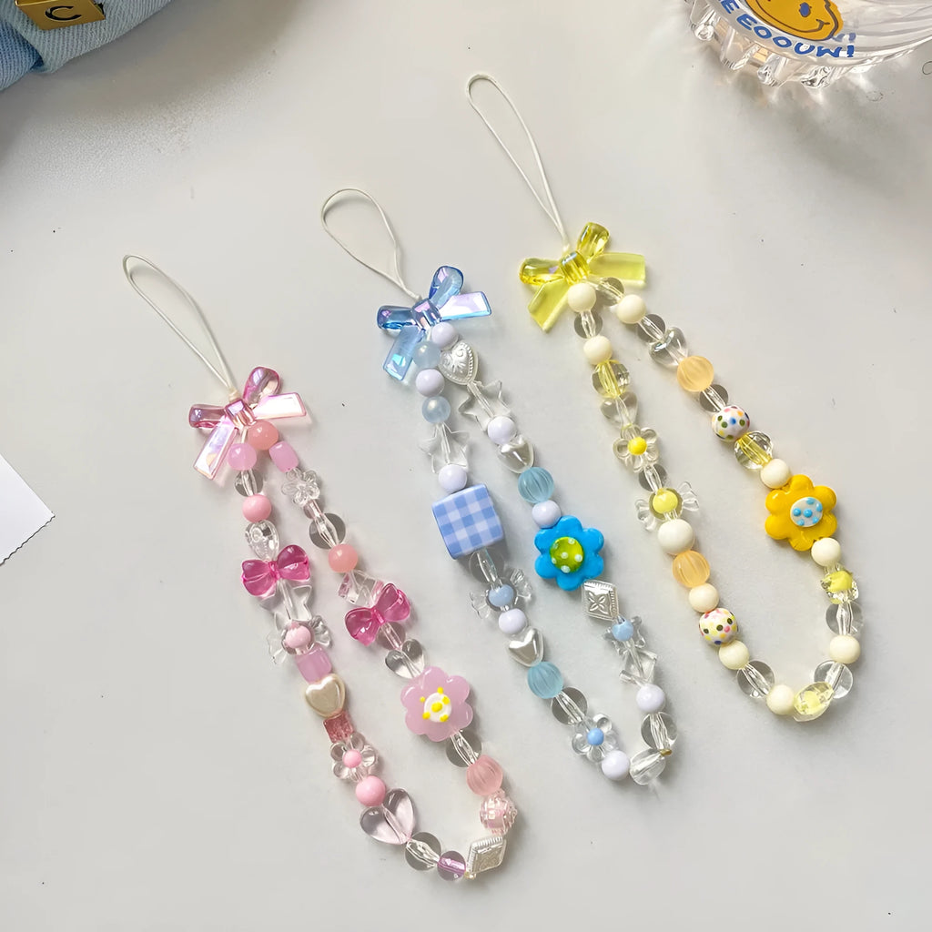Yellow, blue, and pink beaded flower phone lanyard on a hand rope.