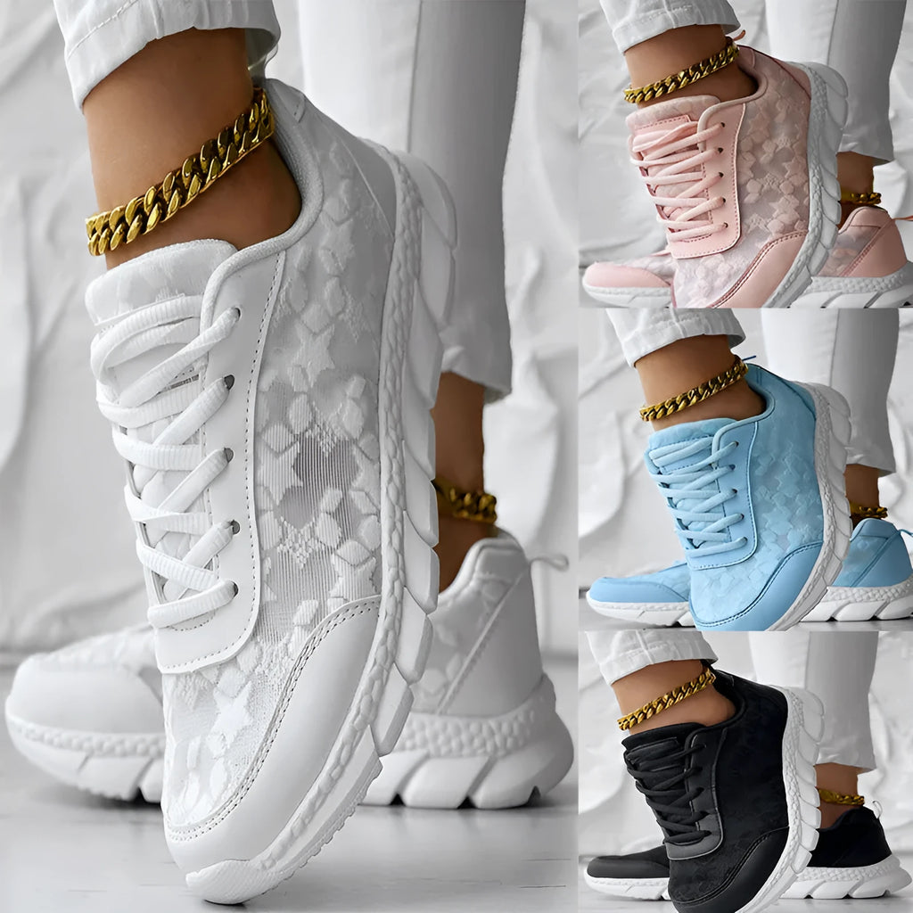 Women's white canvas running shoes with a flat heel and soft sole on a plain background.