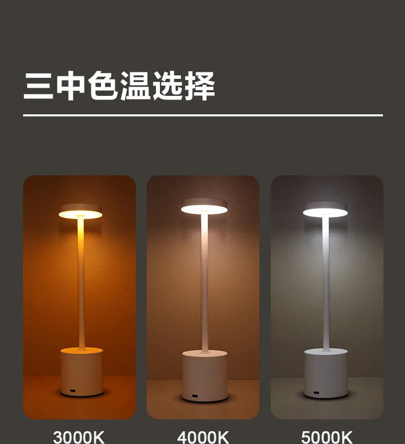 Modern minimalist iron table lamp with silver finish, I-shaped silhouette, emitting warm ambient light on a bedside table