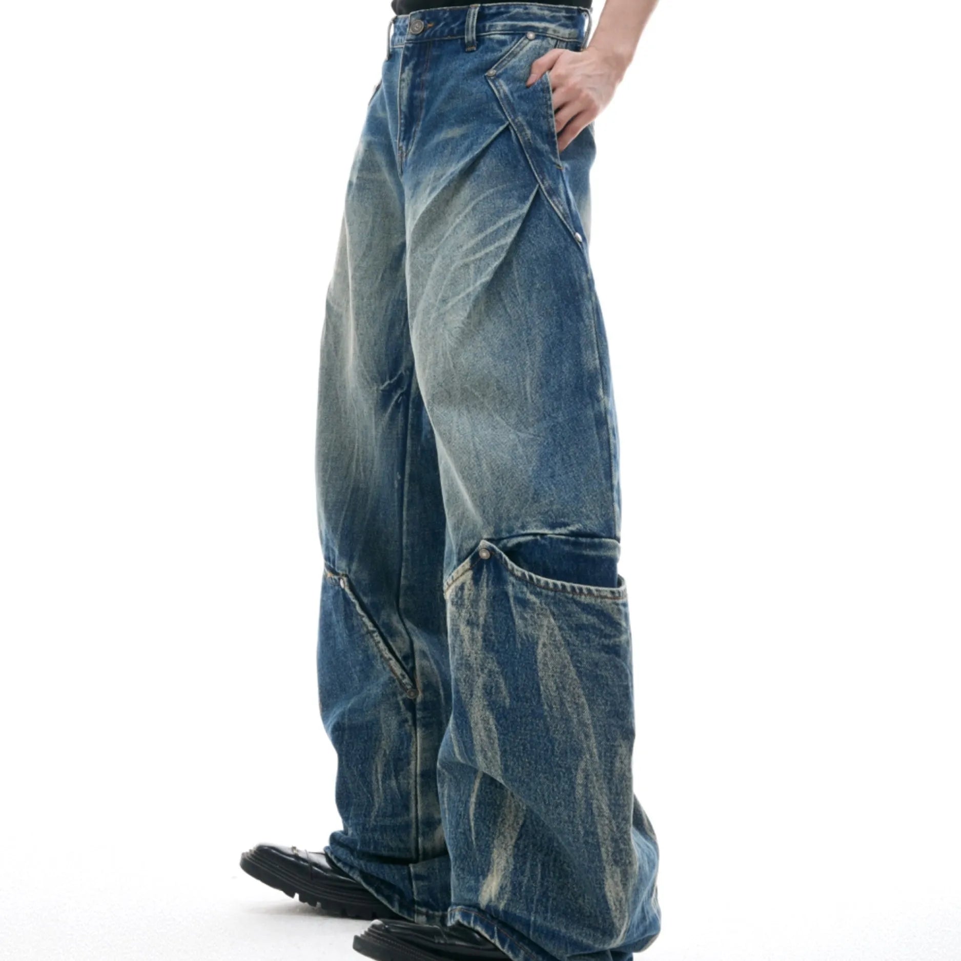 Man wearing Verdant Blue loose fit jeans with a retro washed burst pattern and a curved knife leg silhouette.