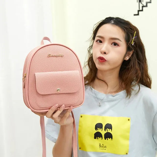 Small black PU leather women's shoulder backpack with zipper, shown next to a mobile phone.