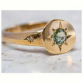 Golden oval ring with a central star-shaped zircon stone on an adjustable band.
