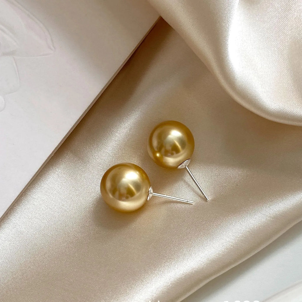 Large geometric pearl stud earrings for women with an eight-point star detail on a silver setting.