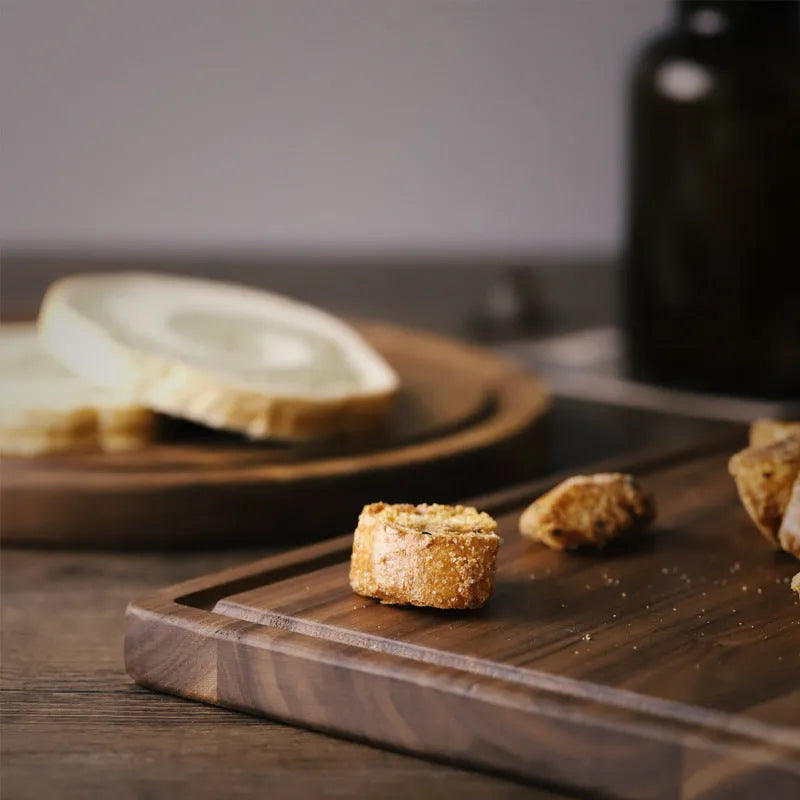 Solid black walnut wood chopping board with juice groove, available in round or rectangular sizes.