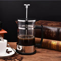 Compact glass French press coffee maker with stainless steel frame, 350ml capacity.
