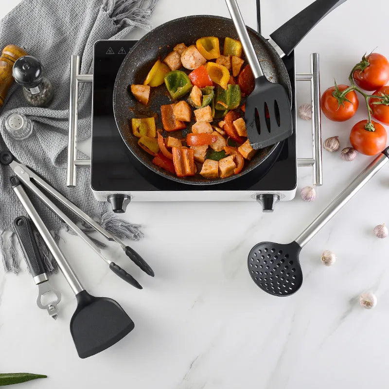 Black silicone kitchen utensil set with stainless steel handles showing four different utensil types
