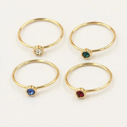 Women's 14K gilded copper knuckle ring with zircon accents in green, shown on a model's finger.