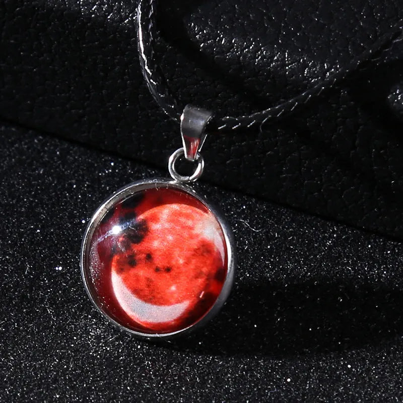 Luminous moon and star constellation pendant necklace with a silver-tone chain on a black background.