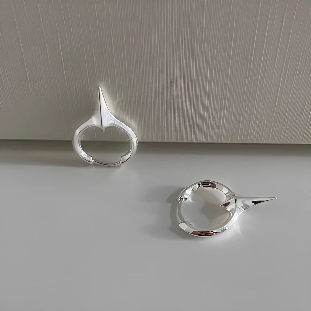 Platinum-coloured star-shaped ear clips with geometric design and clip-on fitting