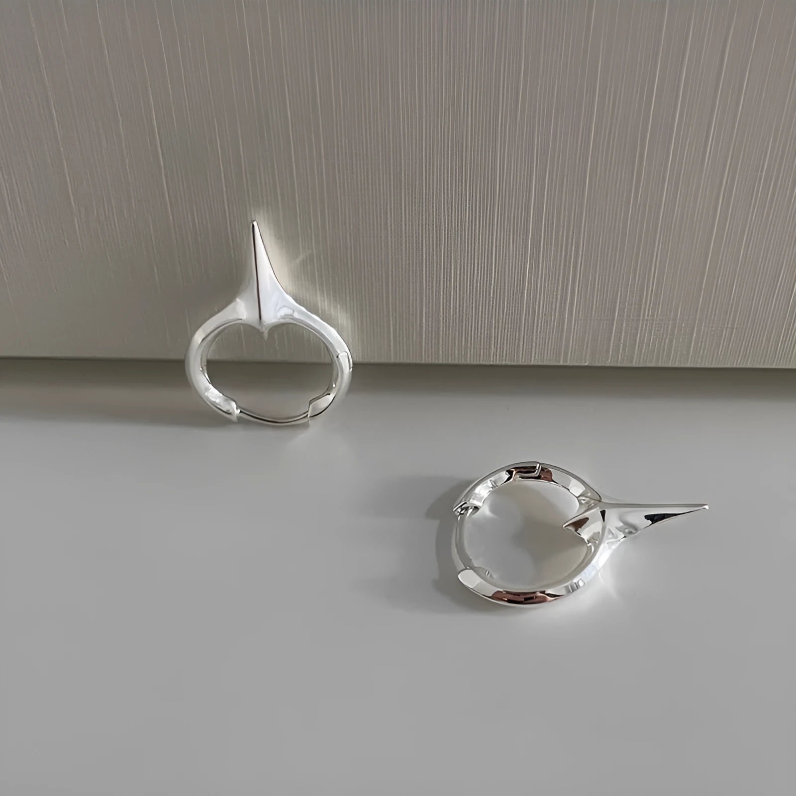 Platinum-coloured star-shaped ear clips with geometric design and clip-on fitting