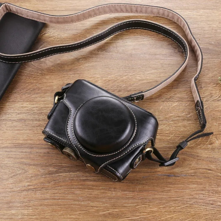 Black imitation leather portable card camera bag with crossbody strap on a solid background