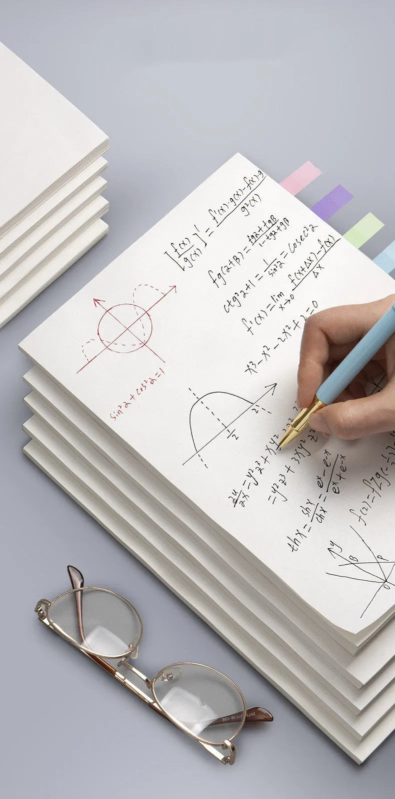A4 blank draft notebook with picture colour cover, open to show unlined pages, placed on a desk with a pen.