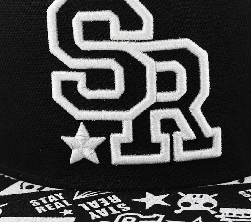 White and black adjustable cotton baseball cap with embroidered letters on the front, showing dome crown and adjustable strap.