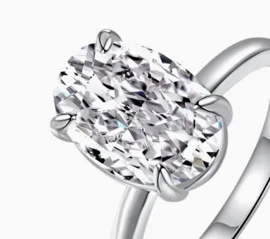 A women's oval sterling silver ring with a four-claw setting holding a single stone.