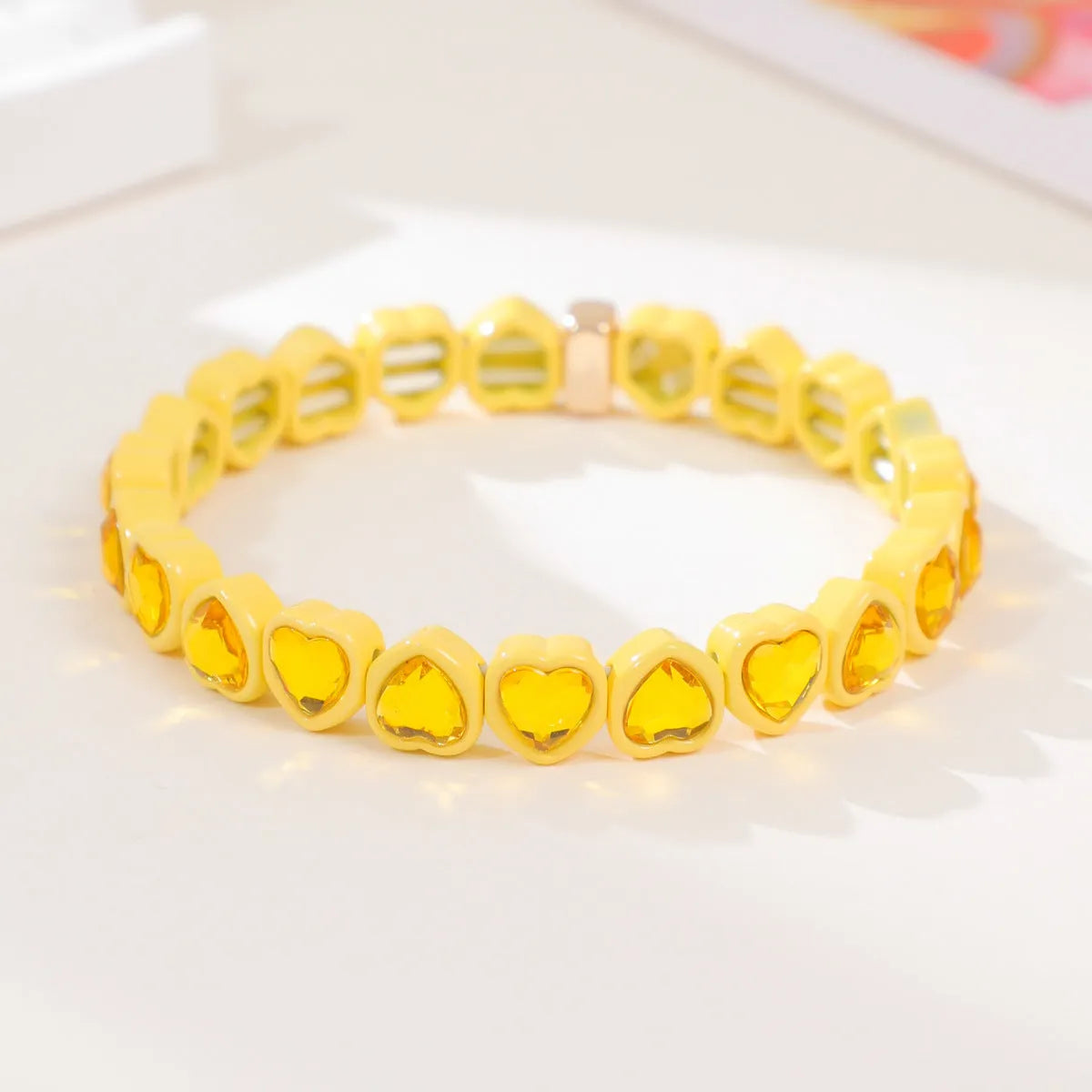 Rainbow enamel heart charm bracelet on alloy base with diamond treatment, stretch band, multicolour design.