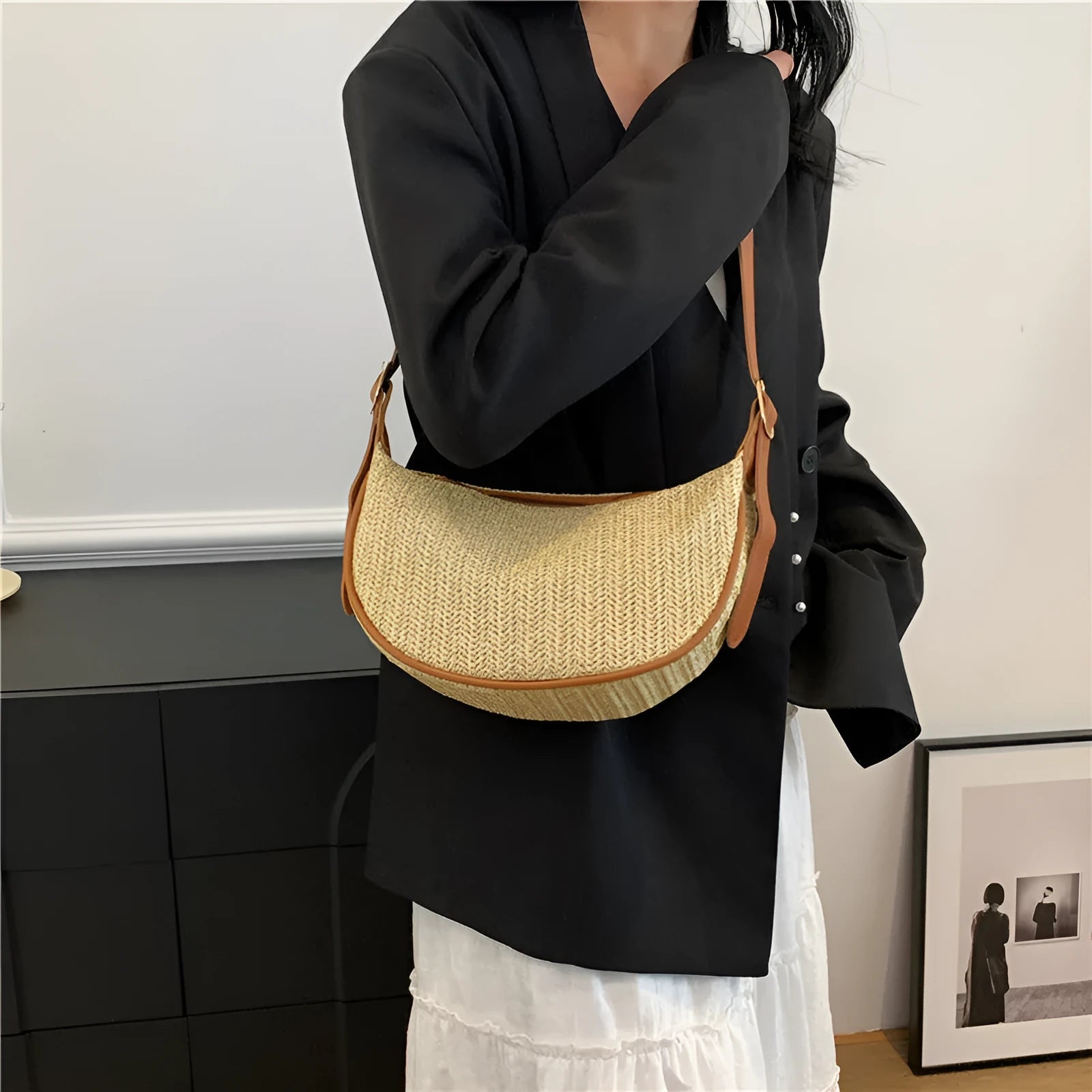 Women's straw woven crossbody bag showing knitted texture and single shoulder strap, shown in corrugated black colour.