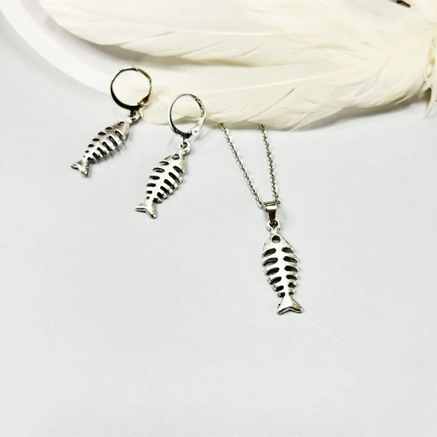 Close-up of retro-style fishbone pendant earrings on an adjustable O-chain.