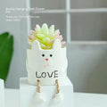 Cartoon-style ceramic hanging foot flower pot for succulent plants on a desktop.