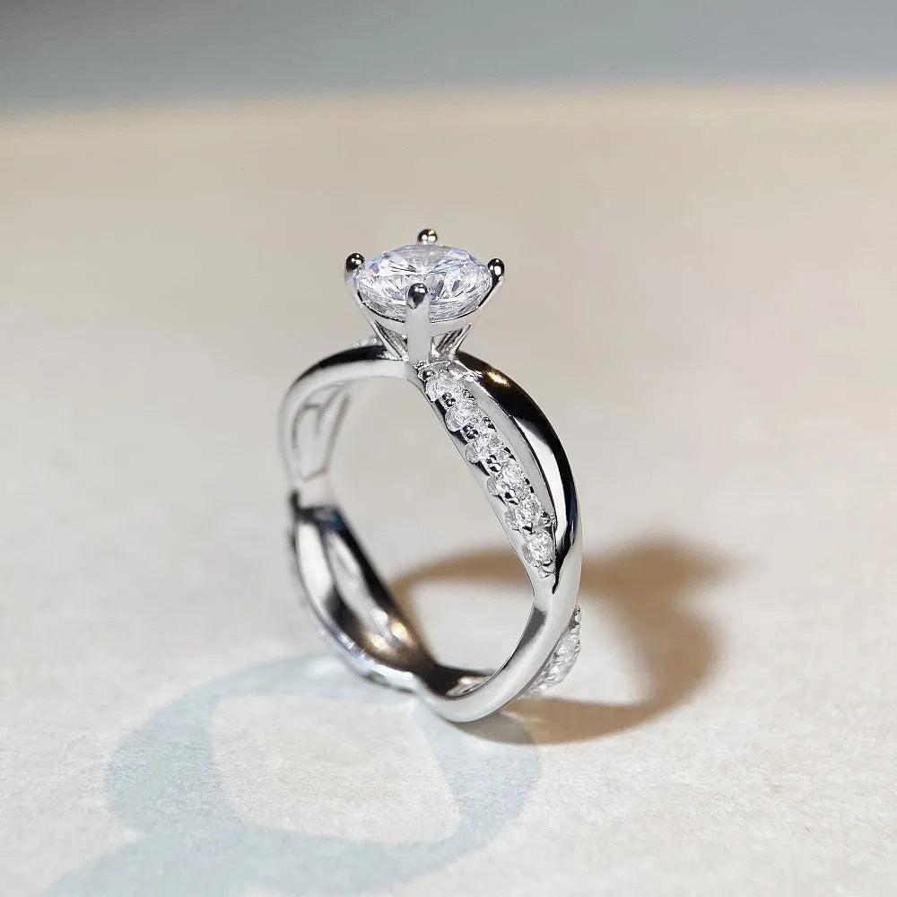 Geometric silver moissanite ring with a 1 karat stone and twisted band.