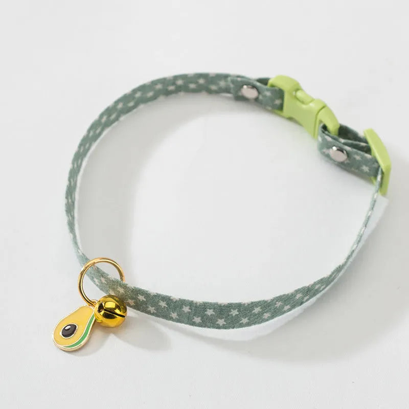 Adjustable green pet collar with a metal bell and a matching bow tie on a small dog.