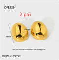 A pair of geometric gold-coloured ear studs with a glazed reflective surface and linear design details.