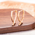 Rose gold plated cross earrings on a white background, showing post and clutch fitting.