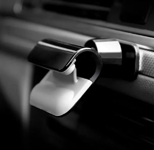 Black 360-degree rotating car phone holder mounted on a car air vent, holding a mobile phone.