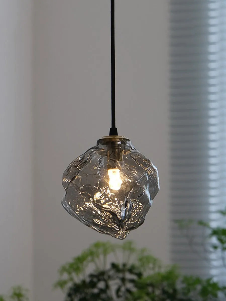 Minimalist ice cube glass chandelier with warm 4000K light, smoky grey shade and black hanging wire over a dining table