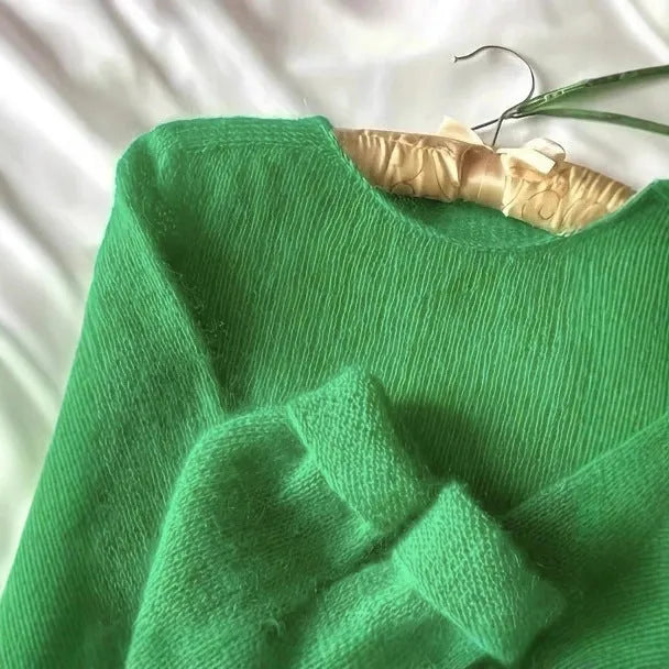 Green crew neck loose fit long sleeve polyester pullover sweater for women on plain background
