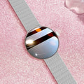 Circular smart watch with metal strap on a woman's wrist, showing colour touchscreen display.