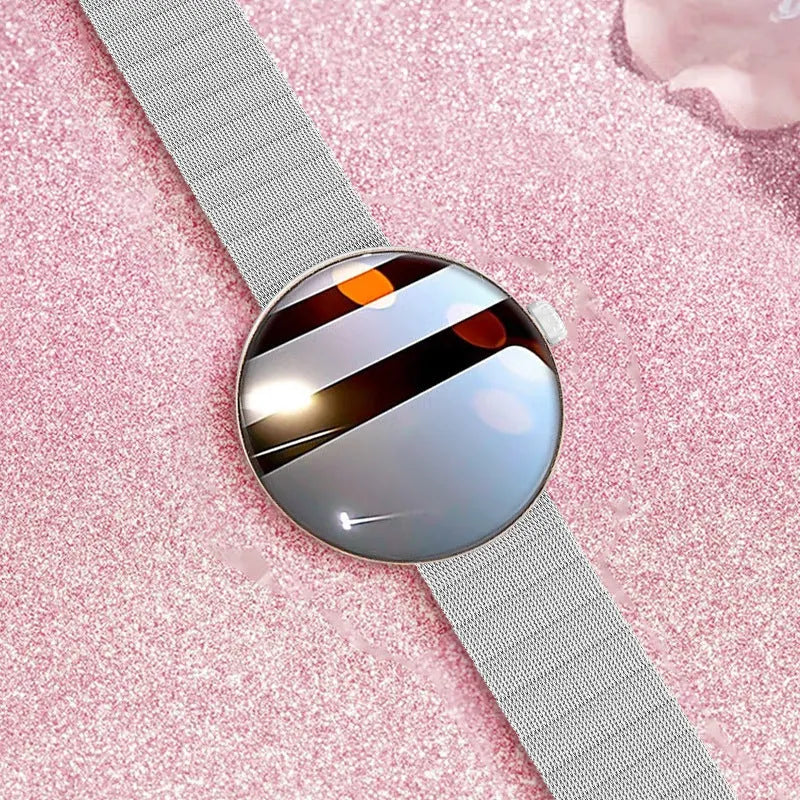 Circular smart watch with metal strap on a woman's wrist, showing colour touchscreen display.