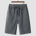 Man wearing beige linen loose-fit cropped shorts on a summer day.