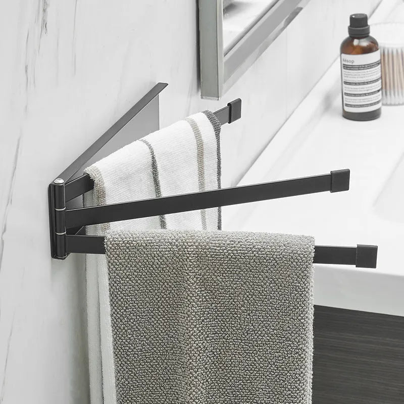 Black folding towel rack mounted on bathroom wall with adhesive installation