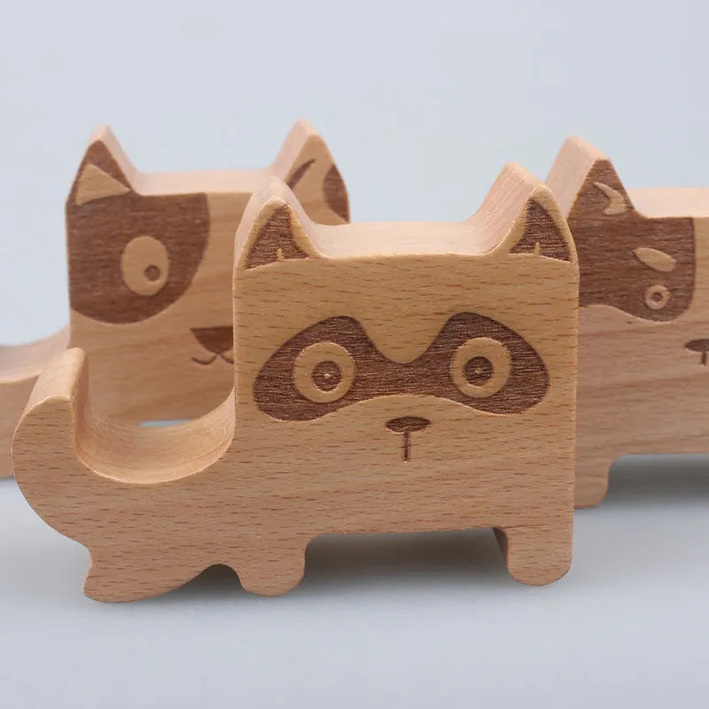 Solid beech wood phone holder with resin puppy decoration and a pound coin in the integrated slot.